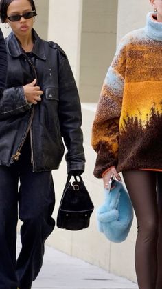 two women walking down the street with one carrying a handbag and another holding a purse