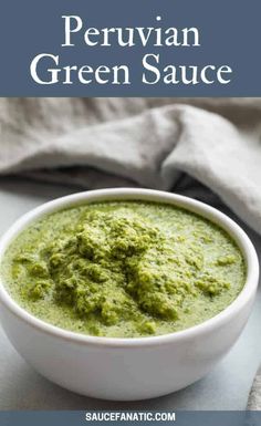 a white bowl filled with pesto sauce on top of a table next to a napkin