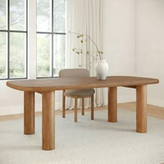 a wooden table with two chairs and a vase on it in front of a window