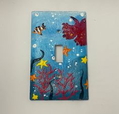 a light switch cover with sea animals painted on it's side and under the water