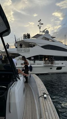 a woman sitting on the back of a boat in front of other boats and people