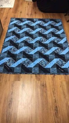 a blue and black rug sitting on top of a wooden floor