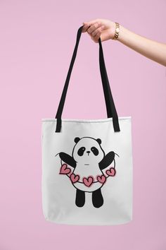 a panda bear with hearts on it's chest holding a white tote bag