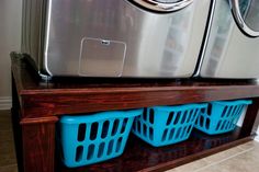 a washer and dryer sitting on top of a wooden shelf