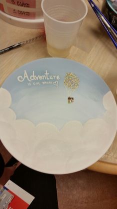 there is a plate on the table that says adventure with a hot air balloon in the sky