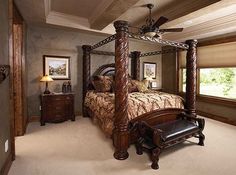 a bedroom with a four post bed and ceiling fan