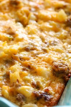 a casserole dish with meat and cheese on it in a blue baking pan