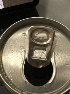 an open can of soda sitting on top of a laptop computer