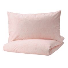 the pink pillow is laying on top of the white bedding and has an intricate pattern