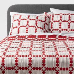 a red and white quilted bed with two pillows