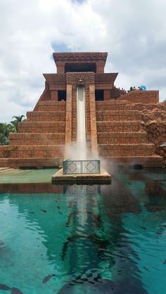 a water slide in the middle of a body of water with fish swimming around it