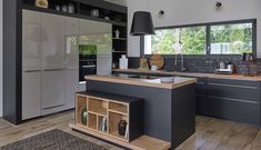 a modern kitchen with an island in the middle and lots of cabinets on both sides