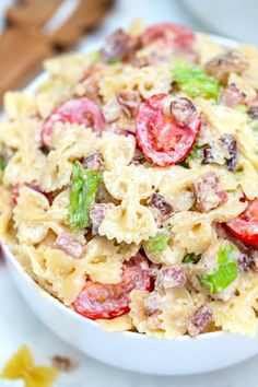 a white bowl filled with pasta salad on top of a table