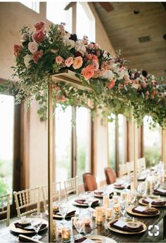 a long table with flowers and candles on it is set for an elegant dinner party