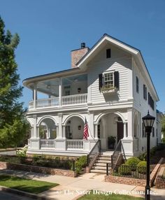 a white two story house with black shutters on the front and second story windows