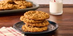 three cookies stacked on top of each other on a plate next to a glass of milk