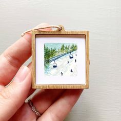 a person holding a miniature painting in their hand