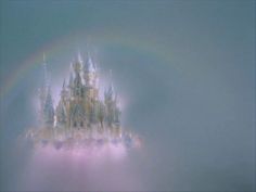 a castle with a rainbow in the background