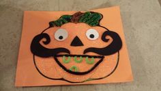 a paper pumpkin with a mustache on it