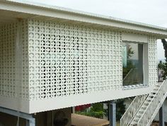 a house with a white perfored wall and stairs