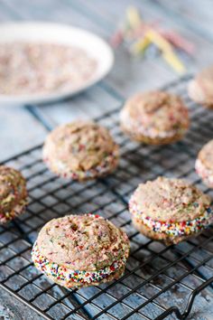 sprinkled cookies cooling on a wire rack next to a plate of cake mix