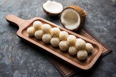 coconuts and sugar on a wooden tray next to a cut in half kiwi