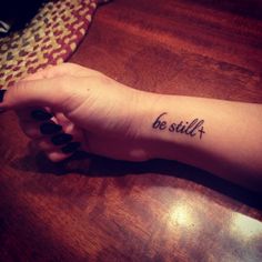 a woman's arm with a tattoo saying be still on the left side of her arm