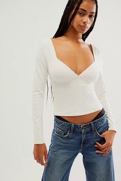 The Free People Duo Corset Long-Sleeve Cami in Ivory is a unique blend of romantic and edgy, making it a standout piece in your wardrobe. This isn't your average cami; it features a built-in corset-style bodice that cinches your waist for a flattering... Stretch White Tops For Date Night, White Stretch Top For Date Night, Fitted White Long Sleeve Top For Fall, White Long Sleeve Top For Date Night, Fitted Feminine Long Sleeve Top, Feminine Fitted Long Sleeve Top For Fall, Fitted Cream V-neck Top, Fitted Feminine Cream Top, Cream Long Sleeve Top For Night Out