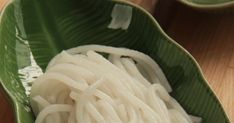 noodles in a green bowl on a wooden table