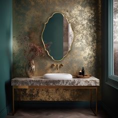 a bathroom with a marble counter top and gold wallpaper on the walls, along with a round mirror