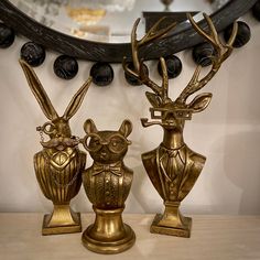 two gold colored vases sitting next to each other on top of a wooden table