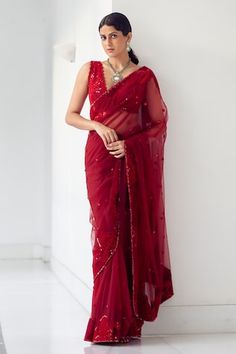 Carmine red saree crafted in soft tulle with rafflesia garden embroidery using tonal sequins, beads and crystals highlights. Paired with a flattering glass neck embroidered padded blouse with scallop border. - Aza Fashions Elegant Red Organza Saree, Red Organza Saree For Festive Occasions, Red Organza Saree With Cutdana, Red Pre-draped Organza Saree, Wedding Red Organza Saree, Red Organza Saree With Unstitched Blouse, Red Saree With Sheer Dupatta For Party, Red Party Wear Saree With Cutdana, Red Party Wear Saree With Sheer Dupatta