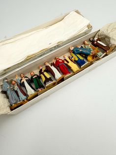 a box filled with figurines sitting on top of a white table next to a cloth covered bag