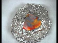 a piece of tin foil with an orange and yellow bird on it's back