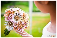 a woman holding a bouquet of flowers in her hand