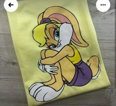 an image of a cartoon character on a yellow t - shirt that is sitting on a wooden floor