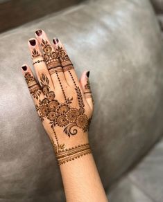 a woman's hand with henna tattoos on it