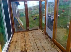 the inside of a house with wooden flooring and glass doors leading to an outside area