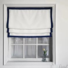 a white window with blue trim on the top and bottom, in front of a white wall