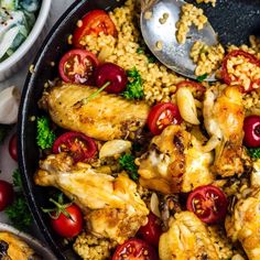 a skillet filled with chicken, rice and cherry tomatoes