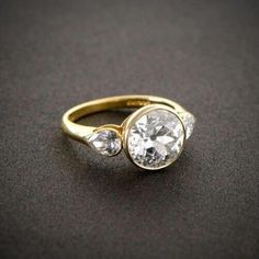 a gold ring with three diamonds on it