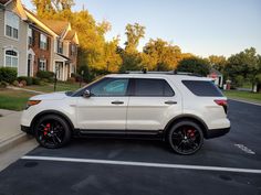 a white ford explorer parked in a parking lot