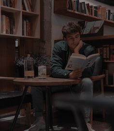 a man sitting at a table reading a book