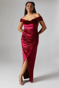 a woman in a red dress posing for the camera with her hands on her hips