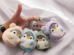 several small stuffed animals are being held by someone's hand