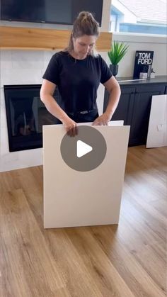 a woman is opening up a box on the floor