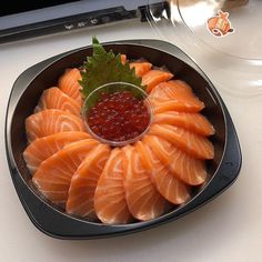 a platter with salmon, cavia and green leaf garnish