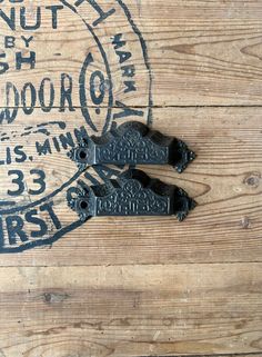 two pairs of black scissors sitting on top of a wooden table