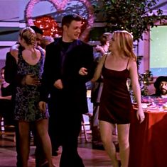 the young man and woman are dancing together in front of other people at a party