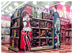 an assortment of dolls on display in a store with pink and white checkered flooring